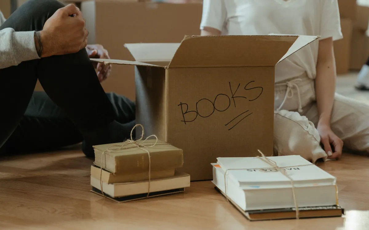 Bücher und Unterlagen werden in einen beschrifteten Karton gepackt