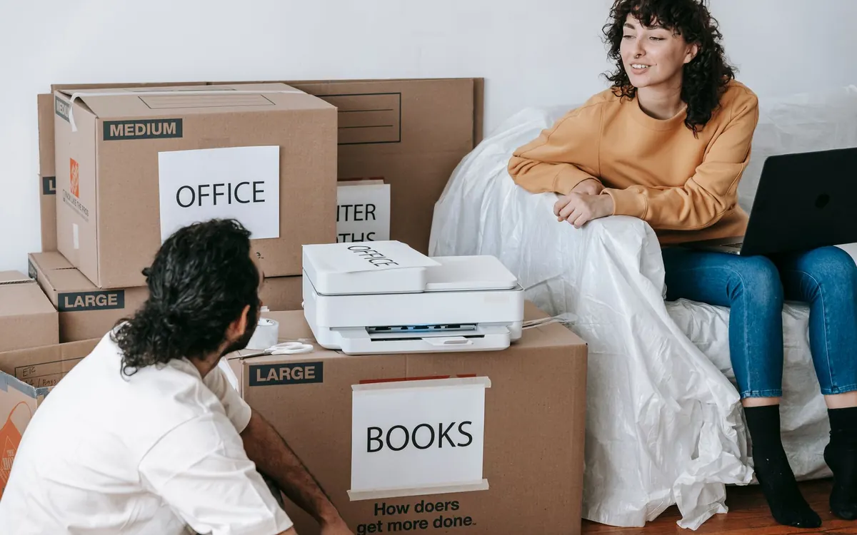 Beschriftete Büro- und Bücherkartons stehen neben einem Arbeitsplatz