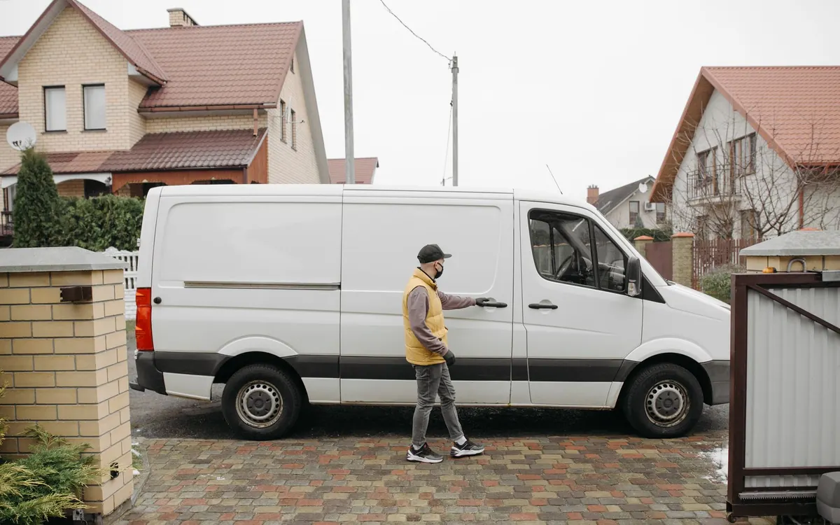 Ein weißer Transporter steht zum Entladen an einer Wohnstraße