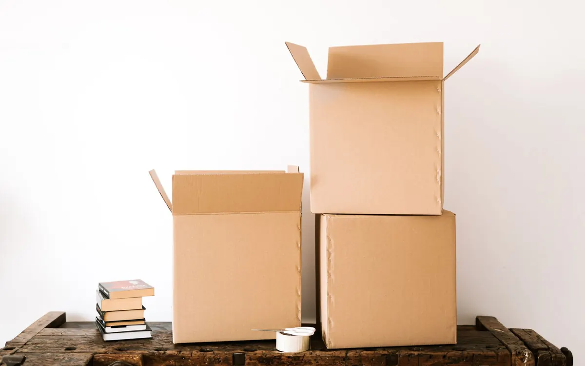 Offene Kartons und Bücher stehen zum Packen bereit